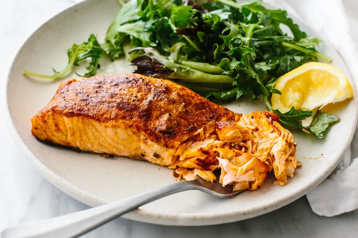 Air fryer salmon on a plate with a salad