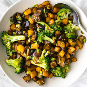 A large white bowl of butternut squash and eggplant stir fry