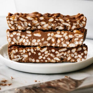 Chocolate crunch bars stacked on top of each other on a plate.