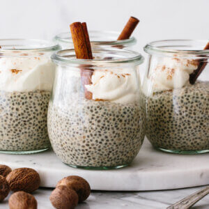 Eggnog chia pudding in glasses on a marble tray.