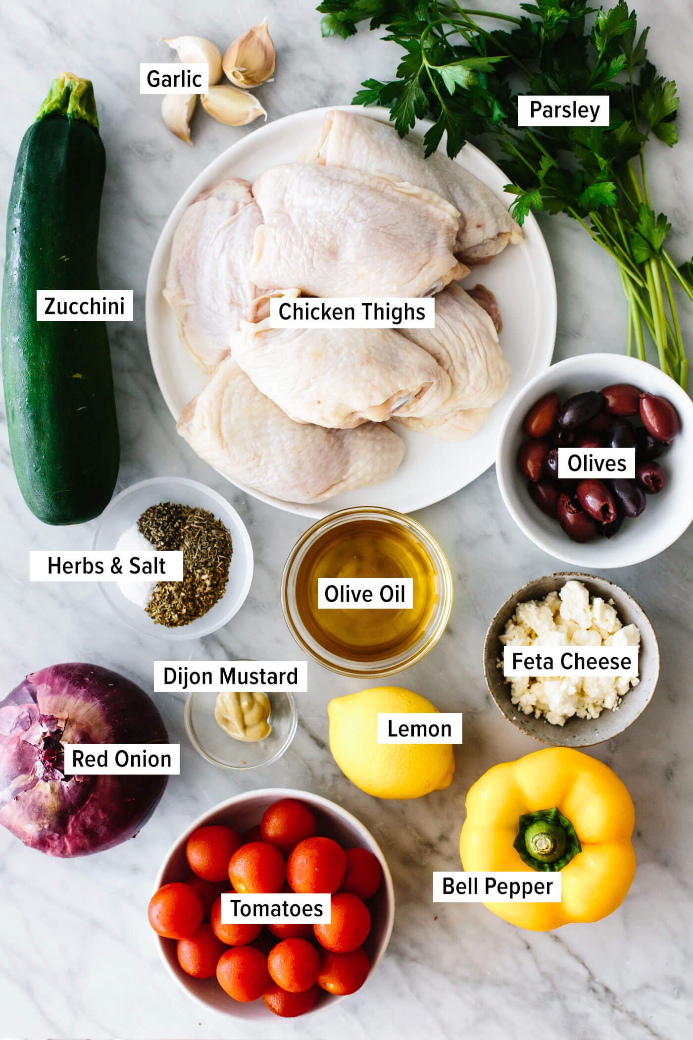 Ingredients for greek sheet pan chicken on a table.