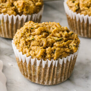 Healthy zucchini muffins staggered on a table.