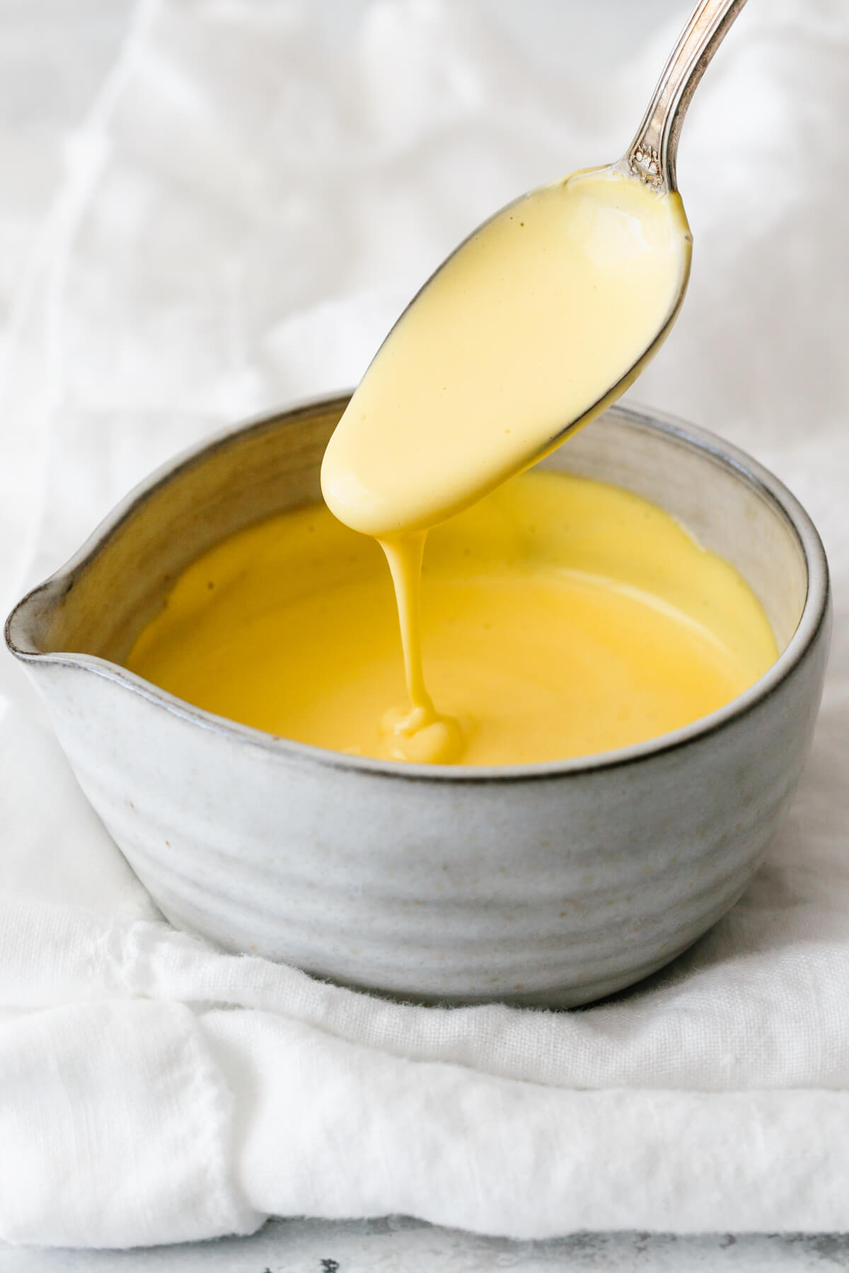 Hollandaise sauce in a small grey bowl.