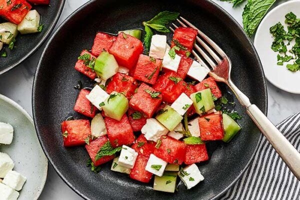 A bowl of watermelon salad with a fork