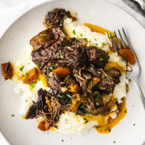 A plate of mashed potatoes and red wine braised short ribs